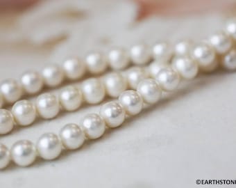 May include: A strand of white pearls, strung together in a classic necklace style. The pearls are smooth and lustrous, with a subtle sheen.