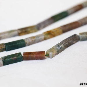 May include: A strand of multi-colored agate beads, each bead is a rectangular shape with a mix of brown, green, and white colors.