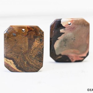 May include: Two octagon-shaped pendants made of brown, black, and pink agate with a hole drilled through the top.