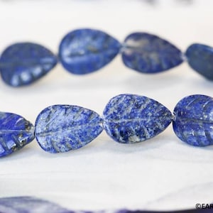 May include: A strand of blue lapis lazuli gemstone beads, each carved in a leaf shape.
