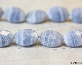 May include: A strand of light blue agate beads with a faceted oval shape. The beads have a banded pattern of light and dark blue.