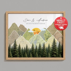 May include: A framed wall art print featuring a mountain range composed of various map segments, including Tokyo, Atlanta, and New York. The design includes a yellow sun, clouds, birds, and a forest of pine trees. Text reads Sam & Andrea and Our Love Is The Greatest Adventure.