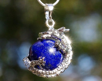 May include: A silver dragon pendant necklace with a round, dark blue lapis lazuli gemstone.