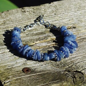 Op de afbeelding: Een blauwe kyanite armband met zilveren kralen en een zilveren kettingsluiting.