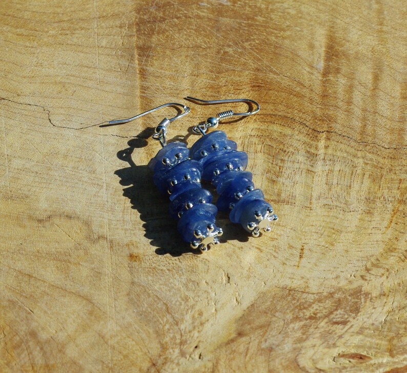 May include: A pair of dangle earrings with blue glass beads and silver accents.
