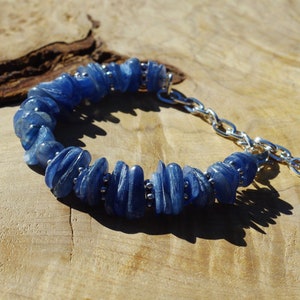 Op de afbeelding: Een blauwe kyanite-stenen armband met een zilveren kettingsluiting. De armband is gemaakt van natuurlijke, onregelmatig gevormde stenen.