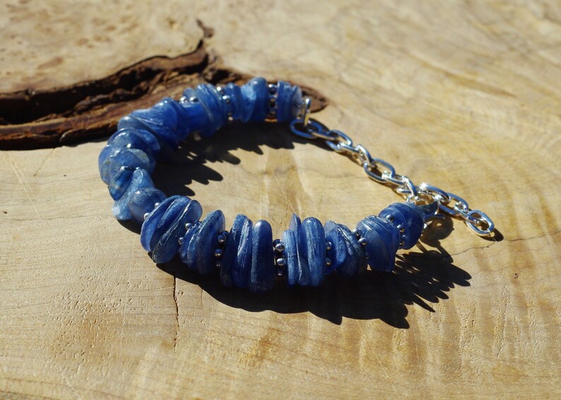 Op de afbeelding: Een blauwe kyanite-stenen armband met een zilveren kettingsluiting. De armband is gemaakt van natuurlijke, onregelmatig gevormde stenen.