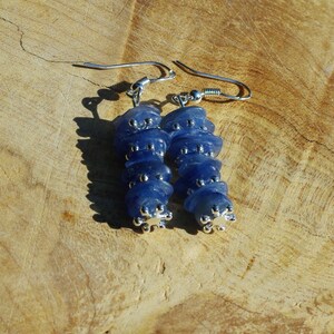 May include: A pair of dangle earrings with a stack of blue gemstone beads and silver accents.