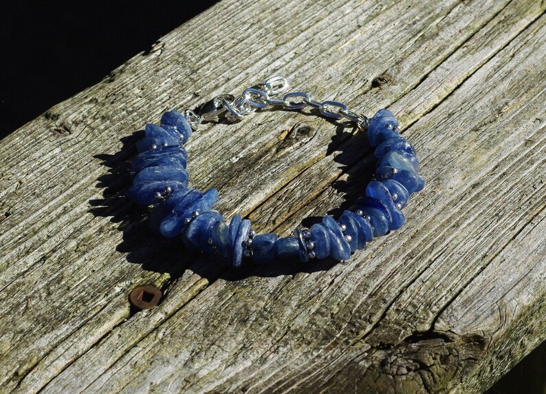Op de afbeelding: Een blauwe edelsteen armband met zilveren kettingschakels. De armband is gemaakt van kleine, onregelmatig gevormde blauwe stenen.