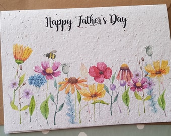 Può includere: Un biglietto bianco con il testo "Happy Father's Day" stampato in nero. Il biglietto è decorato con un'illustrazione ad acquerello di una fila di fiori colorati e un'ape.