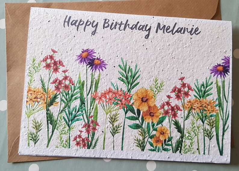 Może przedstawiać: Biała kartka z kwiatowym wzorem i tekstem "Happy Birthday Melanie".