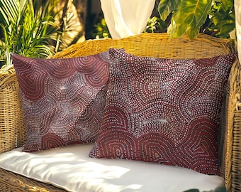 May include: Two square throw pillows featuring a dark red and white dotted pattern. The design consists of intricate, swirling lines formed by small, uniform dots that create a rhythmic, wave-like texture across the entire surface of each pillow.