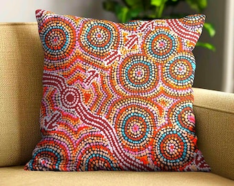 May include: A square throw pillow featuring a vibrant dot art pattern. The design consists of concentric circles and flowing lines in shades of red, orange, yellow, pink, and turquoise. The intricate pattern covers the entire front surface.