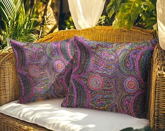 May include: Two square throw pillows featuring a vibrant, intricate dot-art pattern in shades of purple, magenta, blue, and green. The design consists of concentric circles and flowing, curved lines that create a dense, textured visual effect.