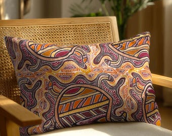 May include: A rectangular throw pillow featuring a vibrant, intricate pattern of interconnected shapes and dotted lines in shades of deep burgundy, bright orange, yellow, and dark purple, creating a dense, rhythmic visual texture across the fabric.