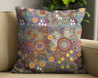 May include: A square throw pillow featuring a dense, intricate dot art pattern. The design incorporates concentric circles, organic shapes, and botanical elements in a vibrant palette of purple, orange, yellow, blue, and white against a dark background.