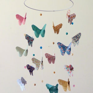 Origami baby mobile with butterflies in green, pink, camel, white, and blue; nursery decoration