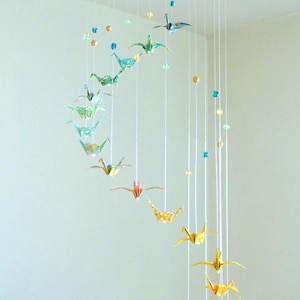 Origami mobile baby, spiral with cranes and glass beads, in green, yellow, golden tones