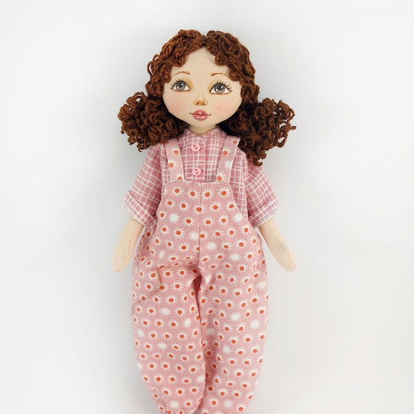 Small handmade rag doll in a jumpsuit