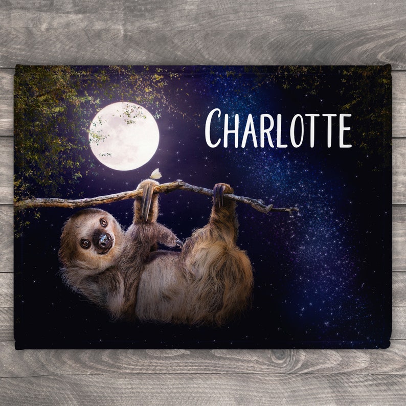 May include: A sloth hangs upside down from a branch with a full moon and stars in the background. The name "CHARLOTTE" is written in white text on the top right of the image.