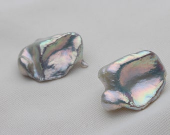 May include: Two iridescent white baroque pearls with an irregular shape.