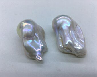 May include: Two large, irregular, white baroque pearls with iridescent sheen.