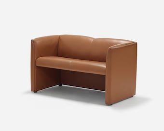 May include: A brown leather two-seater sofa with a simple, modern design. The sofa has a low back and a slightly curved seat.