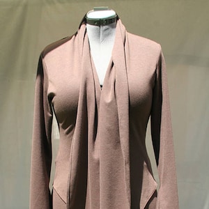 Peut inclure: Une robe longue à manches longues, de couleur marron, avec un col drapé et une silhouette ajustée.