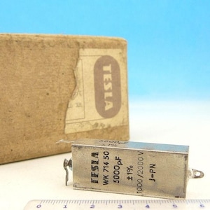 May include: A silver capacitor with the text "TESLA WK 714 50 5000pF ±1% 1000/2000 V J-PN" printed on it.