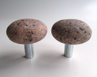 May include: Two round, natural stone knobs with a speckled brown, pink, and gray pattern. Each knob is attached to a silver metal post.