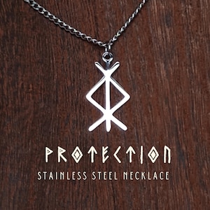 Op de afbeelding: Een zilverkleurige roestvrijstalen ketting met een hanger in de vorm van een geometrisch bindrune-symbool. Onder de hanger staat de tekst PROTECTION in een gestileerd lettertype, gevolgd door de woorden STAINLESS STEEL NECKLACE in een schreefloos lettertype.