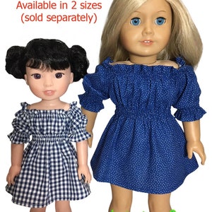 May include: Two dolls wearing blue and white off-the-shoulder dresses. The dress on the left doll is a gingham pattern and the dress on the right doll is a blue dress with white polka dots. The text "Available in 2 sizes (sold separately)" is at the top of the image. The text "appletotes & co." is at the bottom of the image.