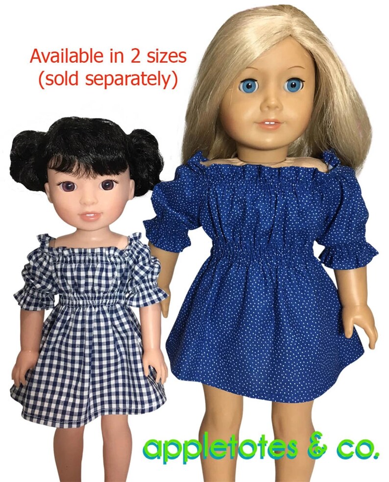 May include: Two dolls wearing blue and white off-the-shoulder dresses. The dress on the left doll is a gingham pattern and the dress on the right doll is a blue dress with white polka dots. The text "Available in 2 sizes (sold separately)" is at the top of the image. The text "appletotes & co." is at the bottom of the image.