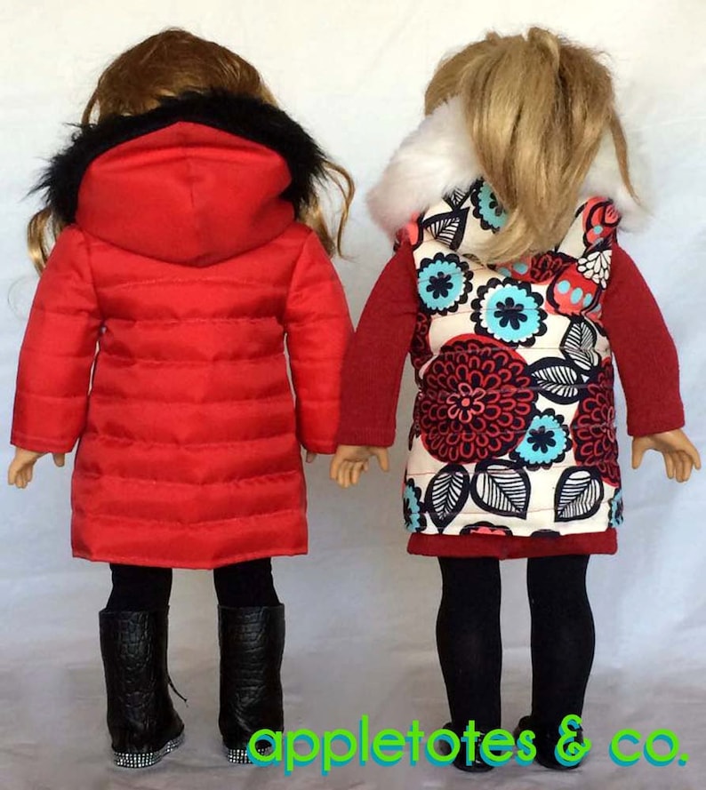 May include: Two dolls wearing winter clothing. The doll on the left is wearing a red puffer jacket with a black fur hood and black leggings. The doll on the right is wearing a red and white floral vest with a white fur collar and black leggings.