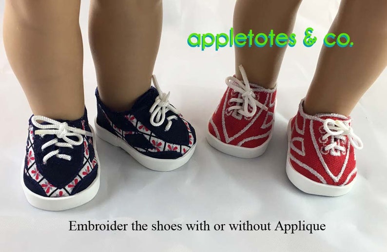 May include: Two pairs of doll-sized sneakers with white soles and red and blue embroidered designs. The text "appletotes & co." is visible above the shoes. The text "Embroider the shoes with or without Applique" is visible below the shoes.