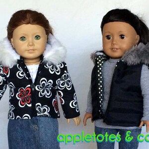 May include: Two dolls wearing winter outerwear. The doll on the left is wearing a black and white puffer jacket with a white faux fur hood. The doll on the right is wearing a black puffer vest with a gray faux fur hood and a gray and white polka dot lining.