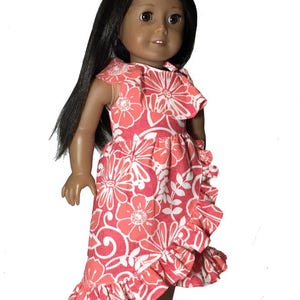 May include: A doll wearing a pink and white floral dress with a ruffled hem. The dress has a scoop neckline and cap sleeves. The doll has long black hair and brown eyes.