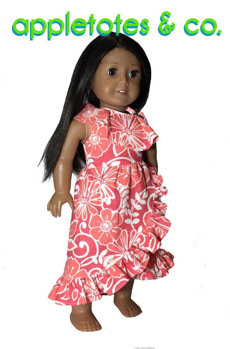 May include: A doll wearing a pink and white floral dress with a ruffled hem. The dress has a scoop neckline and cap sleeves. The doll has long black hair and brown eyes.
