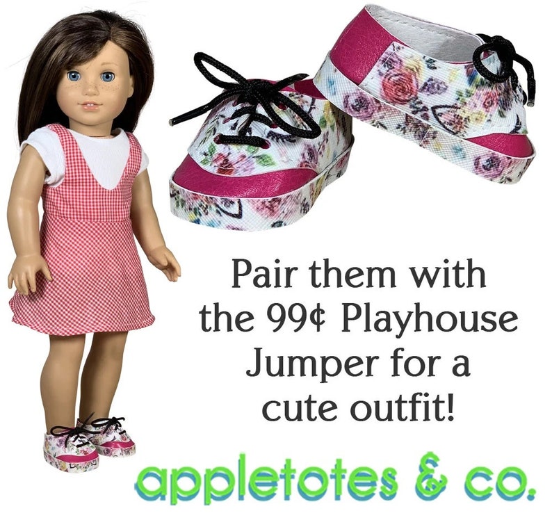 May include: A pair of pink and white floral sneakers with black laces. The sneakers are for a doll and are sitting on a white background. The text "Pair them with the 99&cent; Playhouse Jumper for a cute outfit! appletotes & co." is below the sneakers.