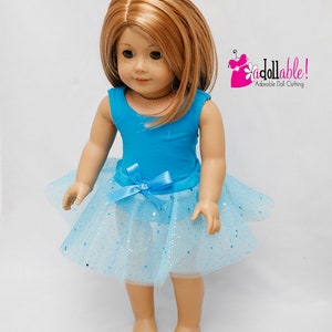 K&ouml;nnte beinhalten: Eine Puppe tr&auml;gt einen t&uuml;rkisfarbenen Trikot und einen hellblauen T&uuml;llrock mit silbernem Glitzer. Die Puppe hat langes, glattes, hellbraunes Haar und blaue Augen. Die Puppe steht auf einem wei&szlig;en Hintergrund. Das Bild enth&auml;lt den Text "a dollable! Adorable Doll Clothing".