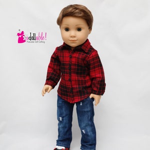 May include: A doll wearing a red and black plaid shirt, blue jeans with distressed details, and black and red sneakers. The doll has brown hair and blue eyes.