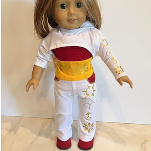 May include: A doll wearing a white and red outfit with gold accents. The outfit includes a white hoodie, a red top, white pants, and red shoes. The outfit has gold geometric designs. The doll has blonde hair and green eyes. The logo "adollable!" is in the top right corner.