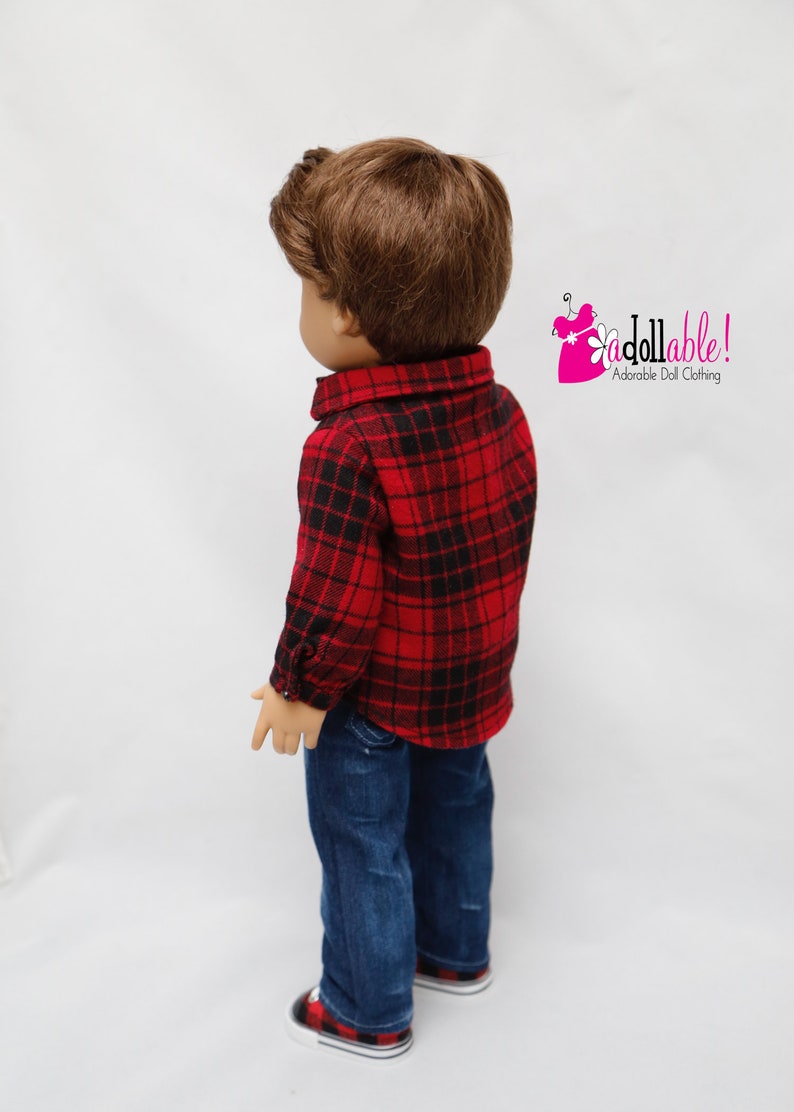 May include: A doll wearing a red and black plaid shirt, blue jeans, and red and black plaid sneakers. The doll has brown hair and is looking to the left. The text "Addollable! Adorable Doll Clothing" is in the upper right corner of the image.