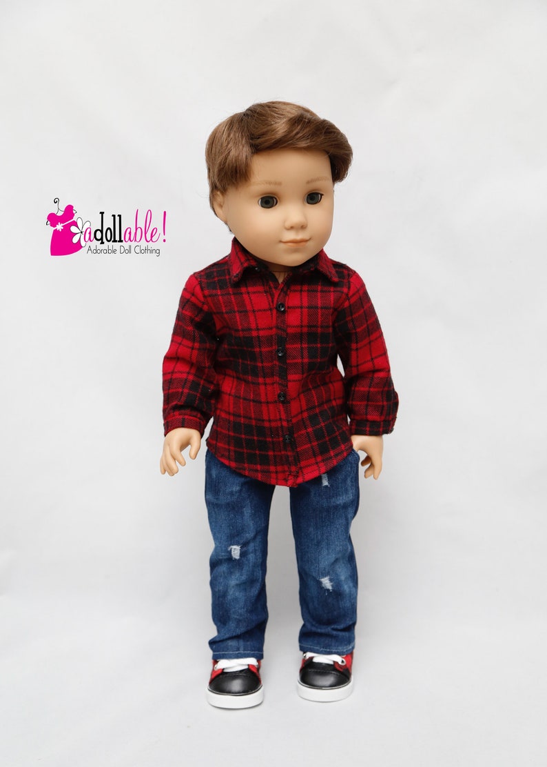 May include: A doll wearing a red and black plaid shirt, blue jeans with distressed details, and black and red sneakers.