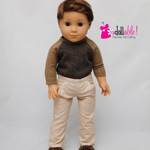 May include: A doll wearing a brown and grey waffle knit shirt with brown long sleeves and beige trousers. The doll is wearing brown shoes. The doll has brown hair and blue eyes. The image includes the text "addollable! Adorable Doll Clothing".