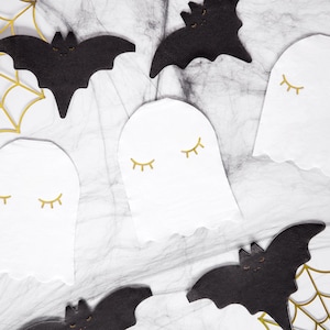 May include: A set of Halloween party decorations featuring black bats and white ghosts with gold eyelashes. The decorations are arranged on a white background with black spiderwebs.
