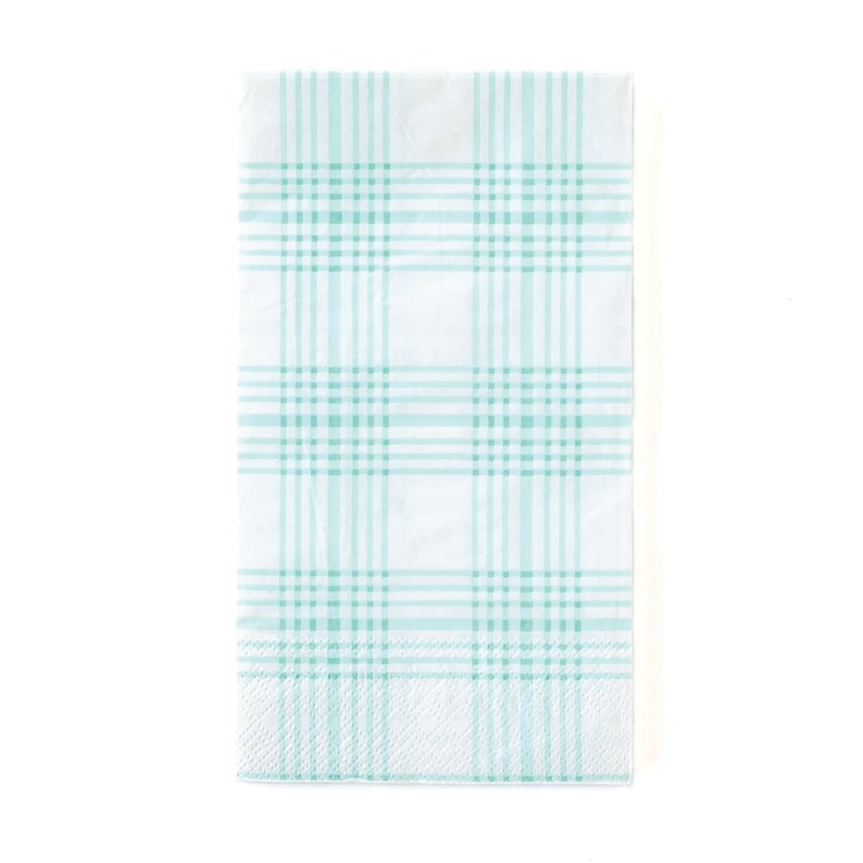 May include: A white paper napkin with a light blue plaid pattern.