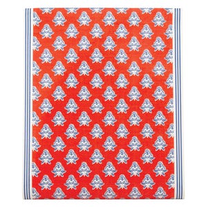 May include: A folded red textile with a repeating pattern of white and blue floral designs. The edges feature a vertical stripe pattern in blue and white. The textile is likely a tablecloth or decorative fabric.