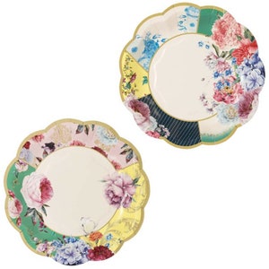 May include: Two floral patterned paper plates with scalloped edges. The plates are white with a variety of floral designs in shades of pink, blue, green, yellow, and black.