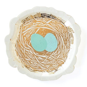 May include: White paper party plate with a gold nest design and two light blue eggs.
